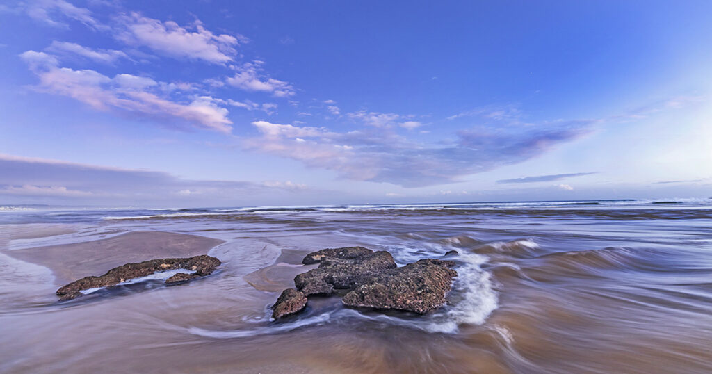 Rocks emerging from the waves at low tide, Klein Brak Beach.