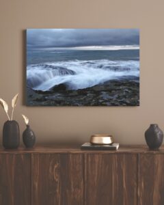 The ocean gently flows over rock and coastline, Mossel Bay.