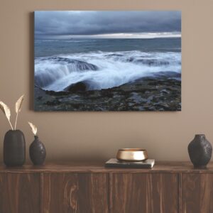 The ocean gently flows over rock and coastline, Mossel Bay.