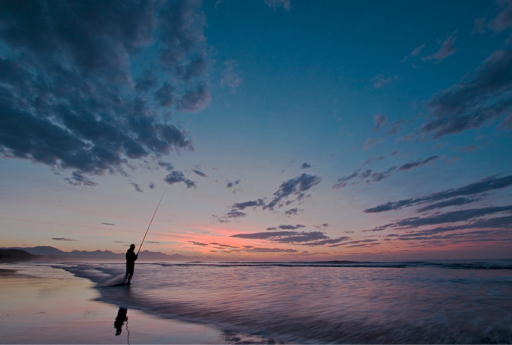 A fisherman posted on Hartenbos beach in a moment of solitude at dawn.